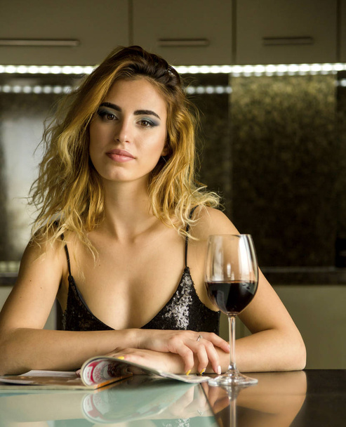 attractive young woman with glass of wine at home - Foto, afbeelding