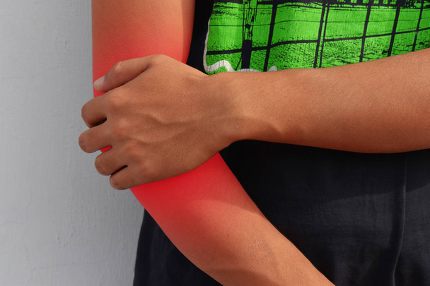 Acute pain in a man elbow. Male holding hand to spot of elbow pain. - Photo, Image
