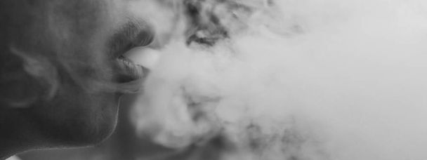 Raucher Mann mit verschwommenem Hintergrund, Konzepte für Gesundheit, selektiver Fokus Schwarz-Weiß-Bild. - Foto, Bild