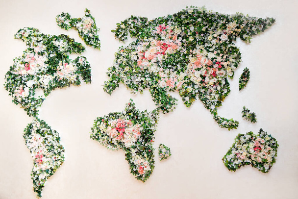 Map of world made from different kinds of flowers, world map on a white wall in the interior, made of flowers. Decor in the big hall. Art Design of the premises - Foto, immagini