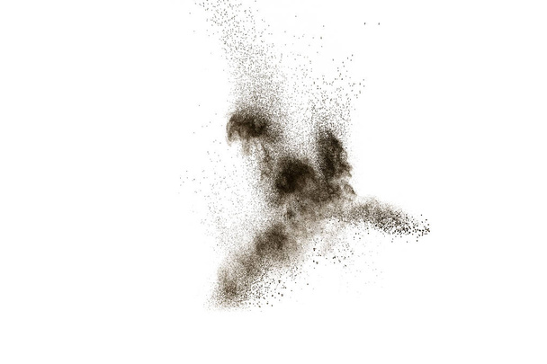 Barna részecskék fröcskölnek fekete háttéren. Barna por felrobban. - Fotó, kép