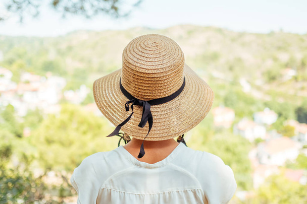 Beautiful woman wearing straw hat looking valley view - Foto, Bild