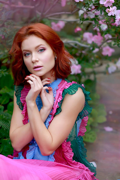 belle fille aux cheveux roux en arrangeur où l'azalée fleurit dans une robe volante colorée
 - Photo, image