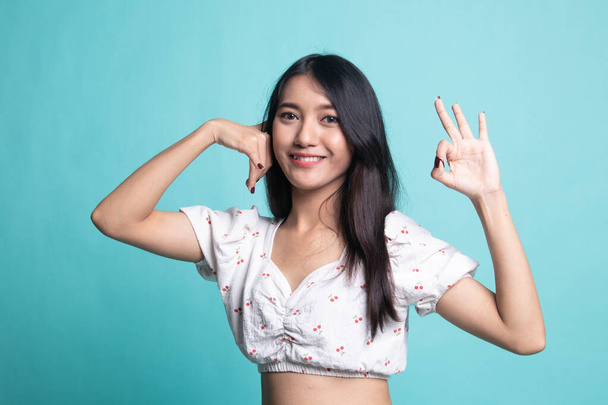 Young Asian woman show with phone gesture and OK sign . - Zdjęcie, obraz
