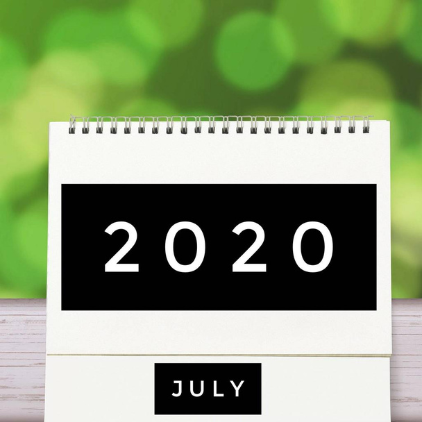Fehér üres papír íróasztal spirál júliusi naptár fa zöld elvont háttérrel. 2020. évi naptár és üres hónap vagy dátum a szöveg és a számok megadásához. - Fotó, kép