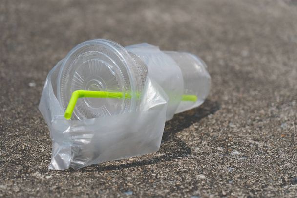 plastic cup put on cement floor, plastic pollution, copy space. stop plastic concept. - Photo, Image