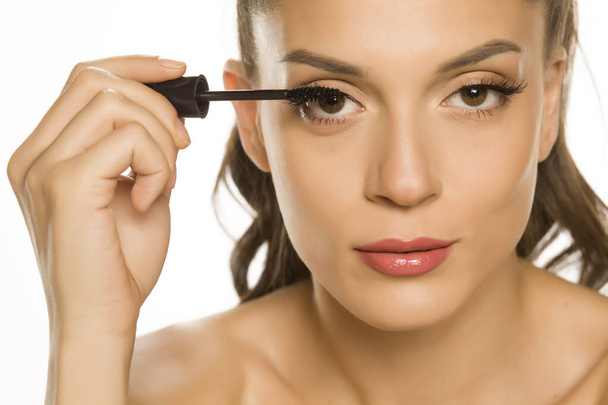 woman applying mascara on her eyelashes - Foto, Imagem