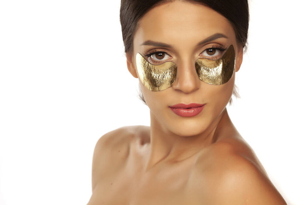 Jonge mooie vrouw poseren met gouden vlekken onder haar ogen  - Foto, afbeelding