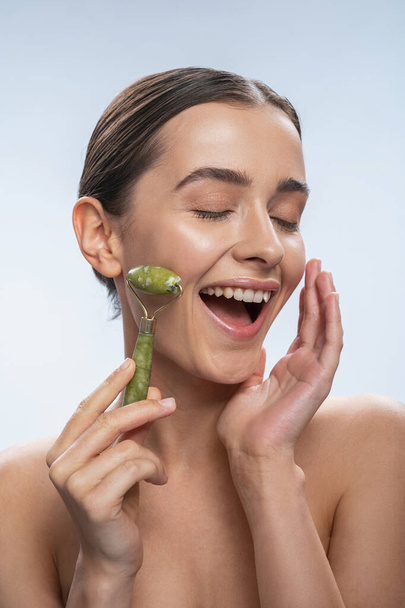 Close up of happy girl that doing face massage - Photo, Image