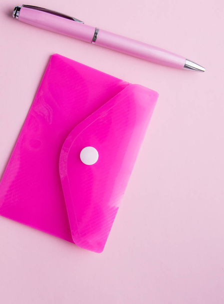 Κάθετο πλαίσιο με ροζ φόντο, Flatley, πλαστικό φάκελο χαρτιού και ροζ στυλό - Φωτογραφία, εικόνα