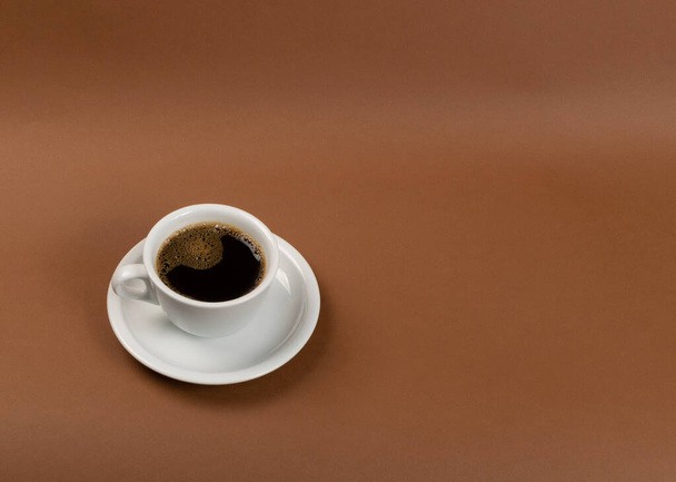 Гаряча чашка кави на коричневому фоні крупним планом
 - Фото, зображення
