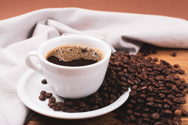 Xícara de café quente e grãos de café no fundo de madeira
 - Foto, Imagem