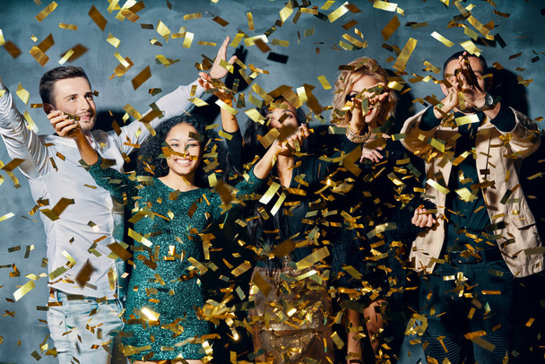 Happy young people dancing and having fun with confetti flying everywhere - 写真・画像