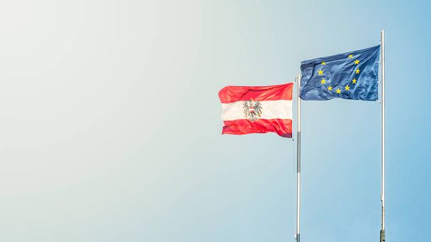 Bandeira com duas bandeiras da União Europeia (UE) e Áustria em pé
 - Foto, Imagem