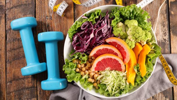 vegetarian salad with meter and dumbbell, healthy food- diet food concept - Foto, immagini