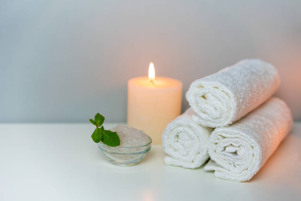 Recreation in SPA concept photo with candle, stack of towels and sea salt for bath. - Φωτογραφία, εικόνα