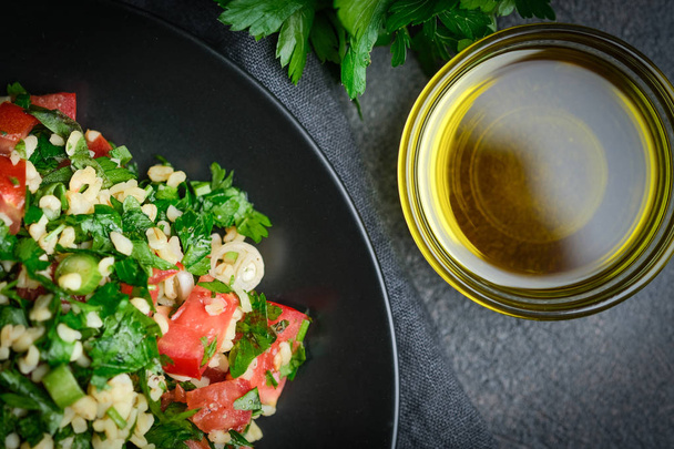 Salade orientale traditionnelle Taboulé avec bulgur et persil sur fond sombre vue du dessus copier l'espace
. - Photo, image