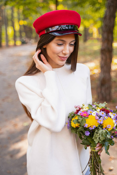 Beautiful young woman holding her colorful flowers - Foto, Bild