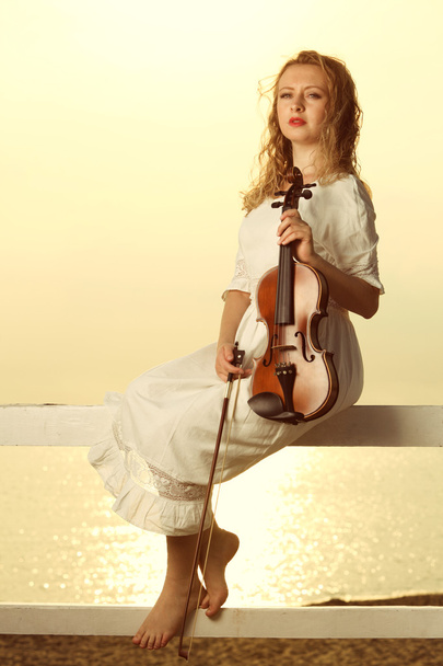 Блондинка з скрипкою на відкритому повітрі
 - Фото, зображення
