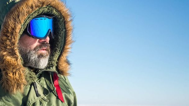 portrait of winter adventurer over sky and snow background. Active healthy sport lifestyle - Valokuva, kuva