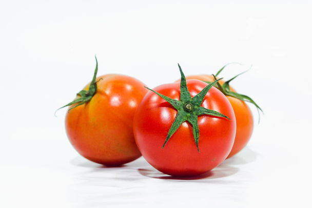 Red tomatoes on the White Blackground , Tomatoes are eaten when ripe, red Or fully ripe orange - Fotó, kép