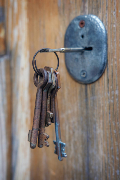 Σετ παλιών σκουριασμένων κλειδιών στην κλειδαρότρυπα - Φωτογραφία, εικόνα