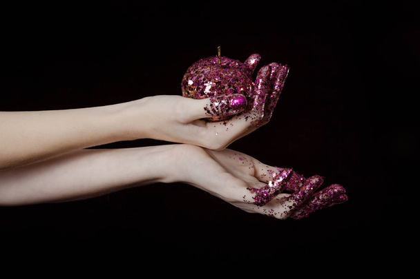 beautiful woman hands with glitter holding apple close up - Foto, Bild