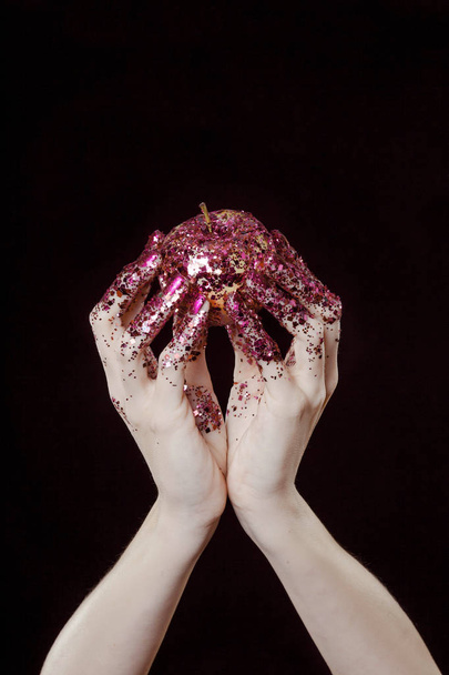 beautiful woman hands with glitter holding apple close up - Foto, afbeelding