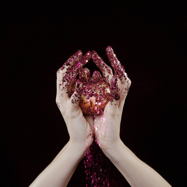 beautiful woman hands with glitter holding apple close up - Foto, afbeelding