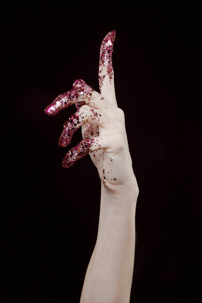 beautiful woman hands with pink glitter in front of black background - Foto, Bild