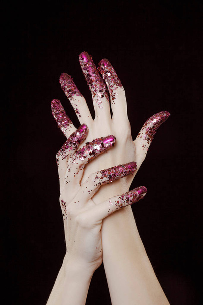 beautiful woman hands with pink glitter in front of black background - Fotoğraf, Görsel
