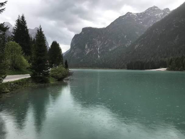 живописный вид на озеро среди гор, покрытых лесом днем
  - Фото, изображение