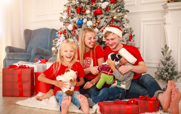 Szczęśliwa rodzina w domu w Boże Narodzenie w pobliżu Nowego Roku drzewa - Zdjęcie, obraz