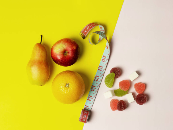 Colored backgrounds are from different sides of good and bad food. In the middle is a measuring tape - Foto, afbeelding