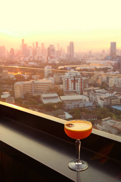 Bicchiere di cocktail sul bar sul tetto con vista aerea urbana sullo sfondo
 - Foto, immagini