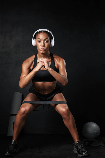 Image of focused african american woman doing sit-ups with expander - Foto, imagen