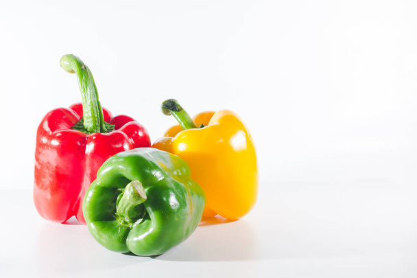 Zoete paprika 's zijn op een witte achtergrond, zoete paprika' s worden gebruikt om te koken en vers te worden gegeten, zoete paprika 's zijn niet-pittige paprika' s. - Foto, afbeelding