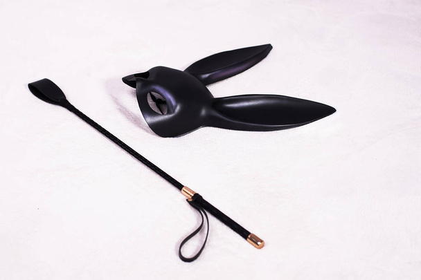kožená králičí maska a bič na posteli - Fotografie, Obrázek