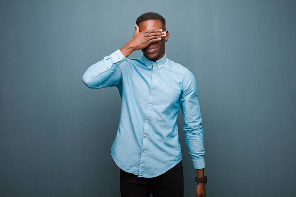 young african american black man covering eyes with one hand feeling scared or anxious, wondering or blindly waiting for a surprise - Фото, зображення