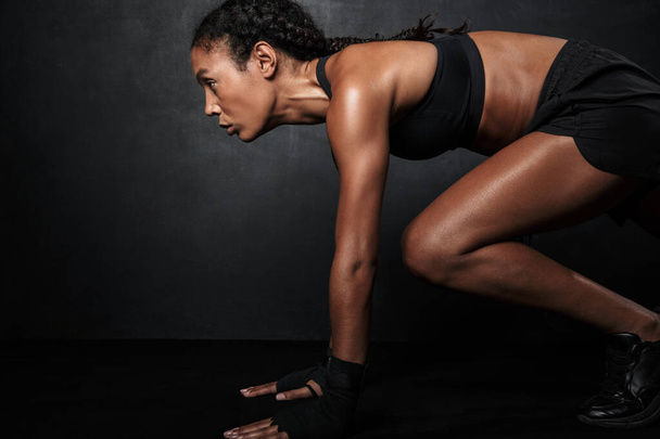 Image of muscular african american woman in sportswear doing workout - Фото, зображення