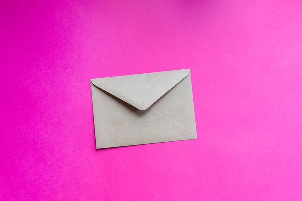 Kraft paper envelope on a purple background - Фото, зображення