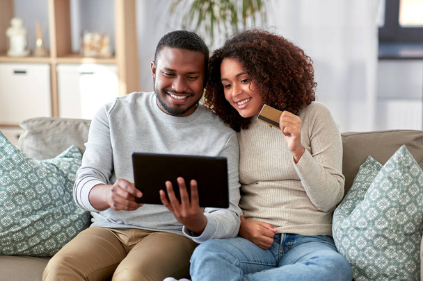 couple with tablet pc and credit card at home - Fotó, kép