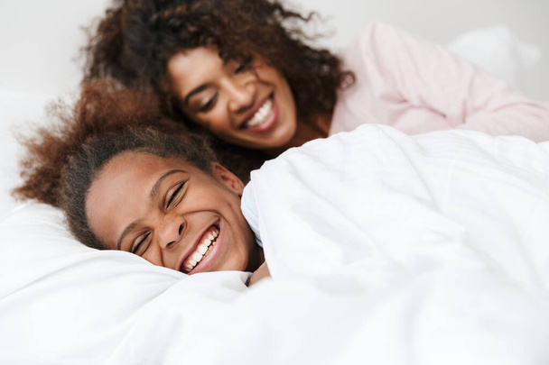 Image of african american woman and her little daughter sleeping - Photo, Image