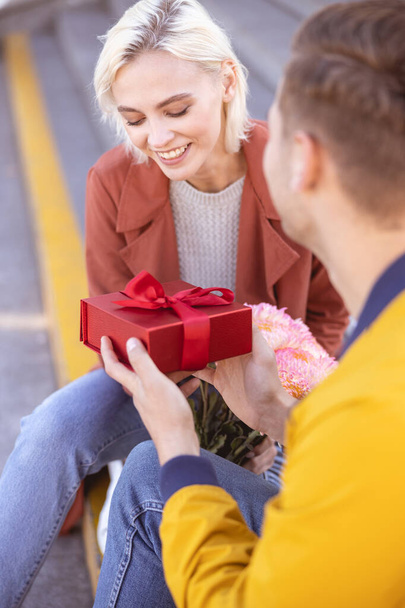 Woman being a little shy while receiving birthday gift - Photo, image