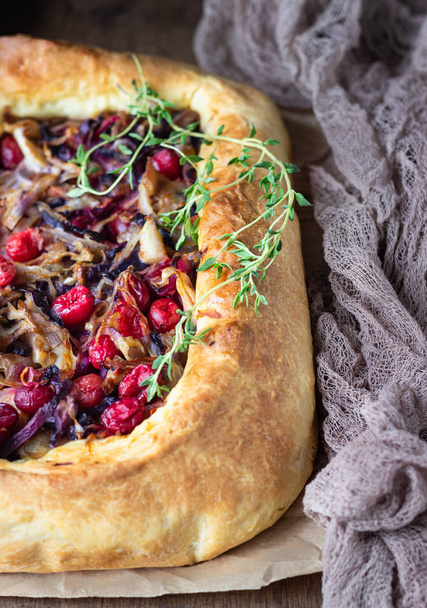 Homemade open pie with different types of cabbage, sauerkraut and cranberry on wooden tray. Selective focus, rustic style. Vegetarian food. - Фото, зображення