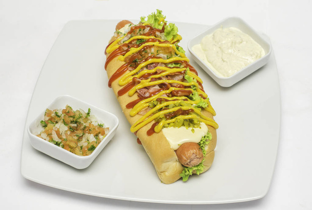 Hot dog dans une assiette avec des sauces
 - Photo, image