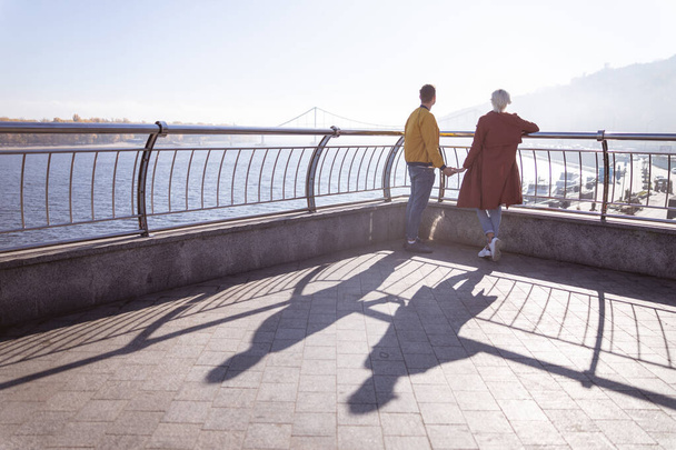 Uomo che cammina con la sua ragazza lungo il fiume
 - Foto, immagini