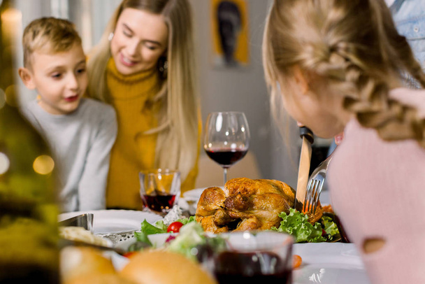 Happy Thanksgiving Day or Merry Christmas. Family sitting at the table and celebrating holiday. Young mother and two children boy and girl. Traditional dinner. - Photo, Image
