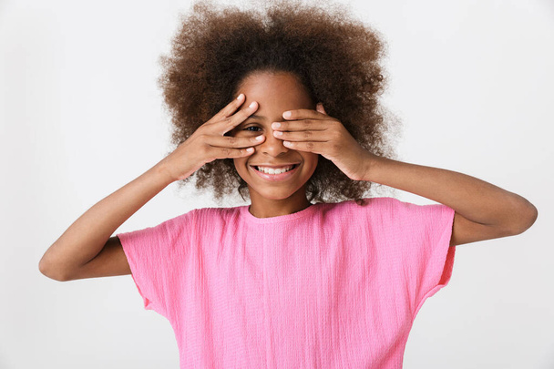 Cheerful little african girl wearing pink blouse standing - Foto, afbeelding