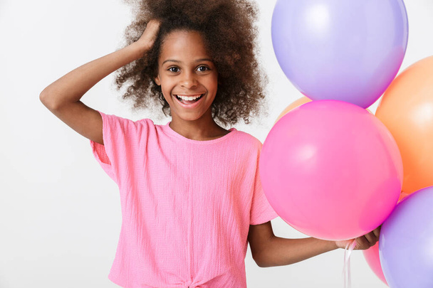 Весела маленька африканська дівчинка в рожевій блузці стоїть
 - Фото, зображення